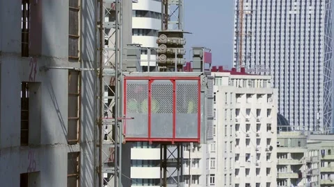 Freight elevator at the construction site of a tall building rides up and down Stock Footage 172484870