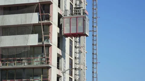 Freight elevator at the construction site of a tall building rides up and down Stock Footage 172484888