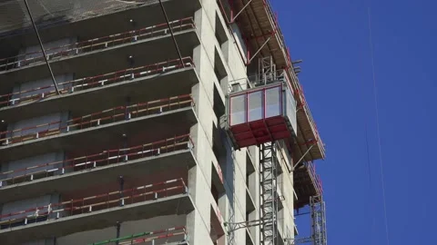 Freight elevator at the construction site of a tall building rides up and down Stock Footage 172484940