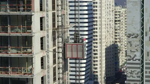 Freight elevator at the construction site of a tall building rides up and down Stock Footage 172484971