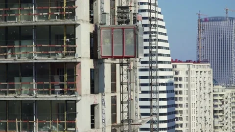 Freight elevator at the construction site of a tall building rides up and down Stock Footage 172485070