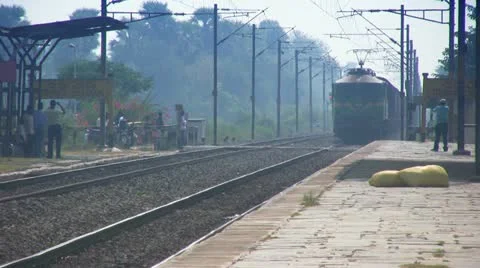 A freight goods train pulled by electric locomotive engine speeds through. Stock Footage 21251563
