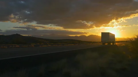 Freight semi truck speeding on empty highway over golden sun at summer sunset Video stock 62303048