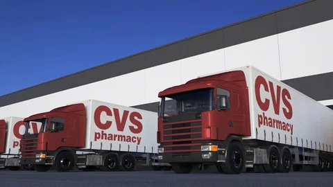 Freight semi trucks with CVS Health logo loading or unloading at warehouse dock Stock Footage