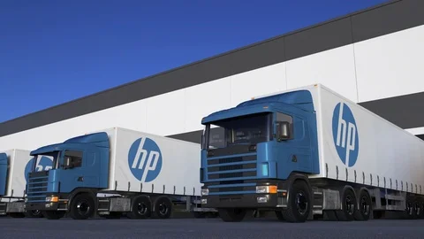 Freight semi trucks with HP Inc. logo loading or unloading at warehouse dock Stock Footage