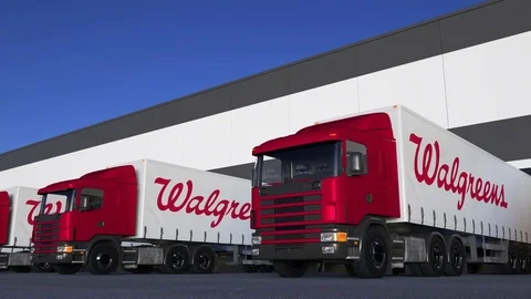 Freight semi trucks with Walgreens logo loading or unloading at warehouse dock Stock Footage