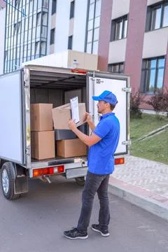 A freight service worker loads a van with parcels for delivery. concept delivery Stockfoto's