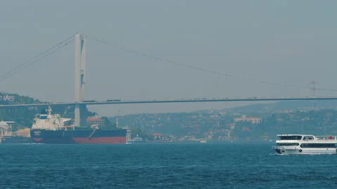 Freight ship sailing under Bosphorus Bridge, ferry ships and boats moving Stock Footage 219499322