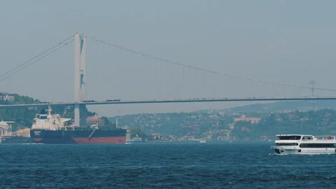 Freight ship sailing under Bosphorus Bridge, ferry ships and boats moving Stock Footage 302270643