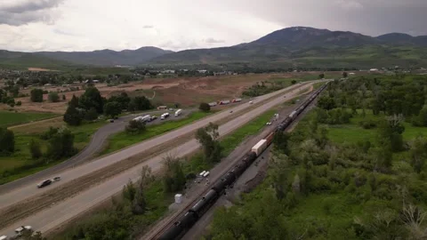 Freight train and highway road mountain on background Stock Footage 248123245