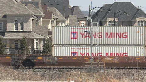 Freight train and shipping containers in residential area with homes close by Stock Footage 151667302