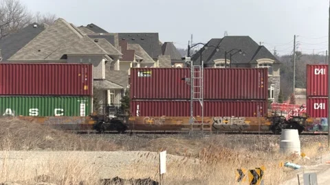 Freight train and shipping containers in residential area with homes close by Vídeo Stock 151667670