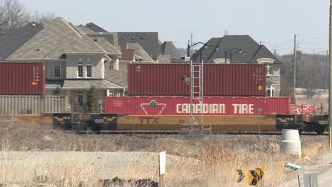Freight train and shipping containers in residential area with homes close by Stock Footage 151667769