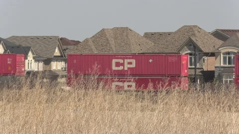 Freight train and shipping containers in residential area with homes close by Vídeo Stock 151667966