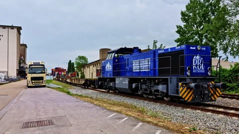 Freight train and truck in front of Stadlagerhaus building at Regensburg port Stock Footage 312221901