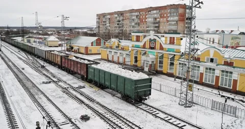 A freight train with bags of lime in open wagons passes by the station building. Video stock 237142094