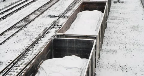 A freight train with bags of lime in open wagons passes along the railway track. Stock-Footage 237142095