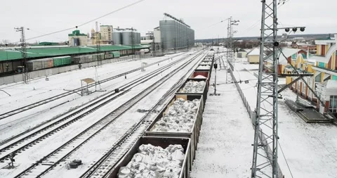 A freight train with bags of lime in open wagons passes by the station building. Stock Footage 237142123
