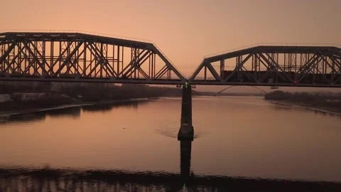 A freight train beautifully passes over the bridge in the rays of a sunny sunset Video stock 162346526