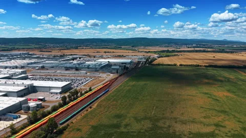 Freight train beside factory and green cropland Stock Footage 340555364