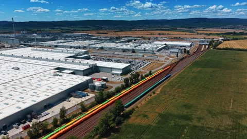 Freight train beside large manufacturing plant Stock Footage 340554430