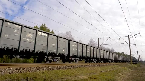 Freight train with cargo containers passing by on spring day in Lithuania Stock Footage 254329193