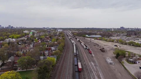 Freight train carrying cargo passing through suburban residential neighborhood, Stock Footage 334697177