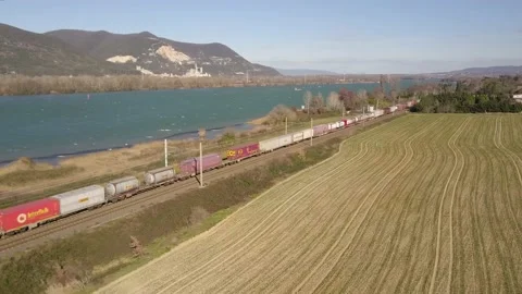 Freight Train Carrying Cargo Rides Through Railway By The Main Rhone River Vídeos de archivo 237931543