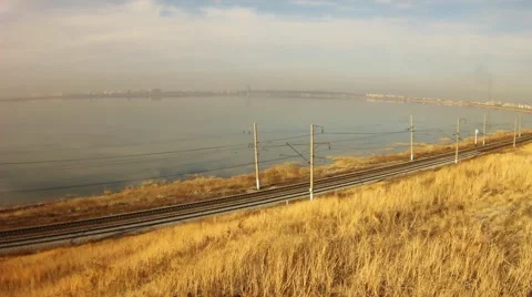 Freight train carrying  containers. In the background is a beautiful lake. Video stock 64636240