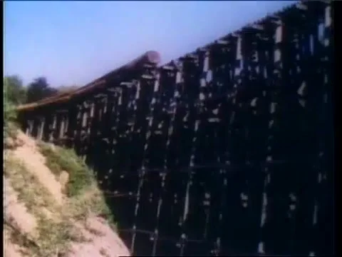 Freight train carrying logs falling off collapsing bridge, 1950s Stock Footage 58857345