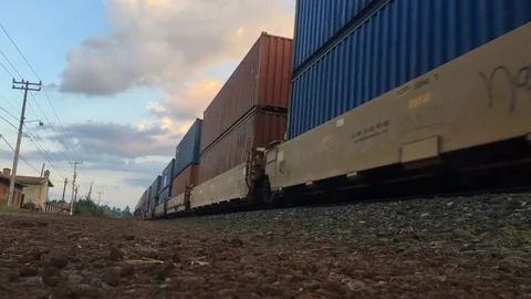 A freight train carrying shipping containers moving along railroad tracks Video stock 72364187