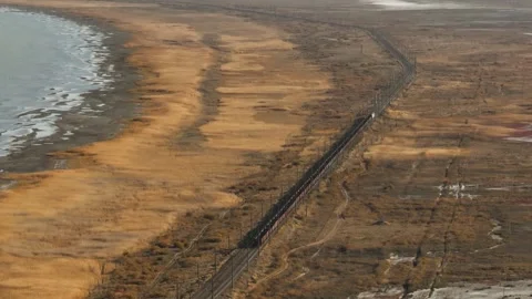 Freight train coal carries with cargo carriages in arid flat plain steppe. Railw Vidéo 264022519