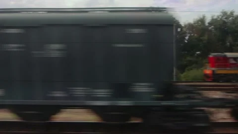Freight train with colorful wagons passes on parallel tracks. Side view from A Stock Footage 318907391