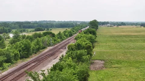 Freight train coming in over green trees. Stock Footage 243597756