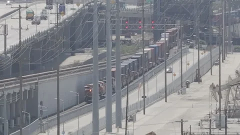 Freight train coming through harbor city, tracking a car driving Stock Footage 291138292