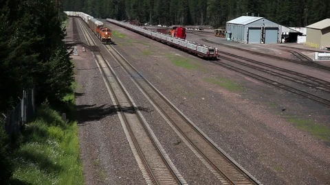 Freight train with containers approaches; passes under Stock-Footage 90523129