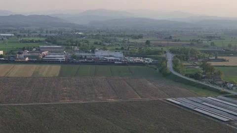 Freight train crossing Po Valley farmland near Fiorenzuola d’Arda at sunset Stock Footage 334084691