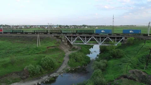 Freight train crossing railway bridge in summer day Vídeos de archivo 76509262