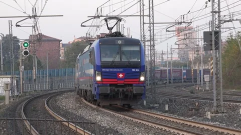 Freight train on curved track in a scenic open-air setting, hauled by a pair Stock Footage 292641155