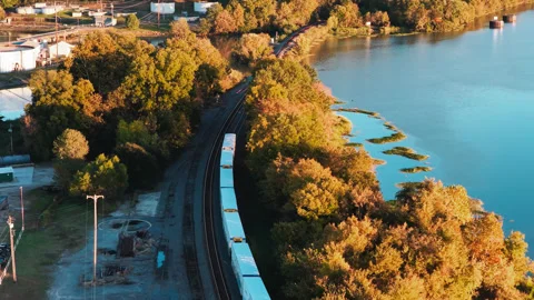 Freight Train Curving Beside Blue River and Autumn Trees in Ozark Vídeos de archivo 344221700