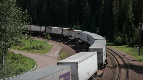 Freight train departs around bend in track Stock Footage 90520929