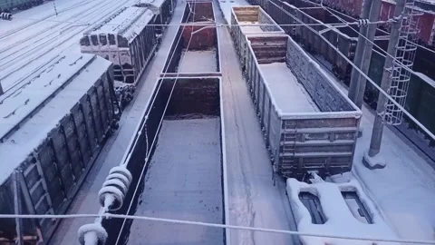 Freight train with empty bulk cargo containers rides at the station in winter Stock Footage 168712060