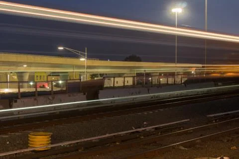 Freight Train fast motion blur passing station hub. Night time long exposure Stock Photos