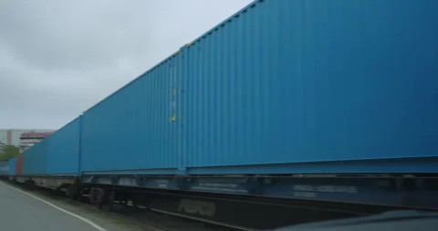Freight train filled with containers reflecting pale light Видео 319831879