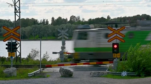 A freight train full of logs passing a level crossing Stock Footage 247571735