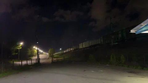 Freight train goes over the highway at night Stock Footage 308818866