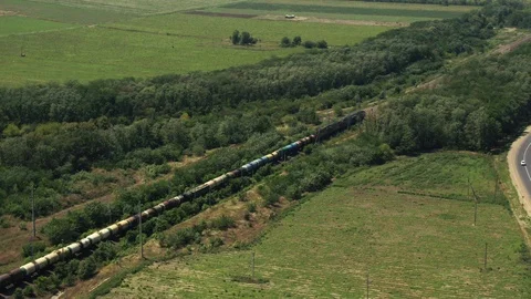A freight train is going past forests and fields Stock Footage 101576768