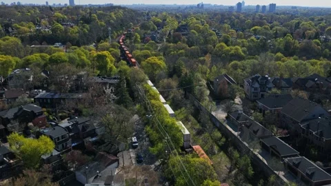 Freight train with intermodal containers moving through a residential neighborho Stock Footage 334696922