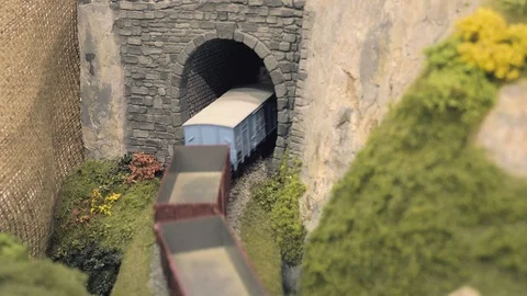 Freight train leaves tunnel. Model railroad track. Rail transportation Stock Footage 89116890