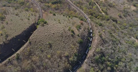 Freight train meandering around winding tracks in the African countryside Stock-Footage 95912530